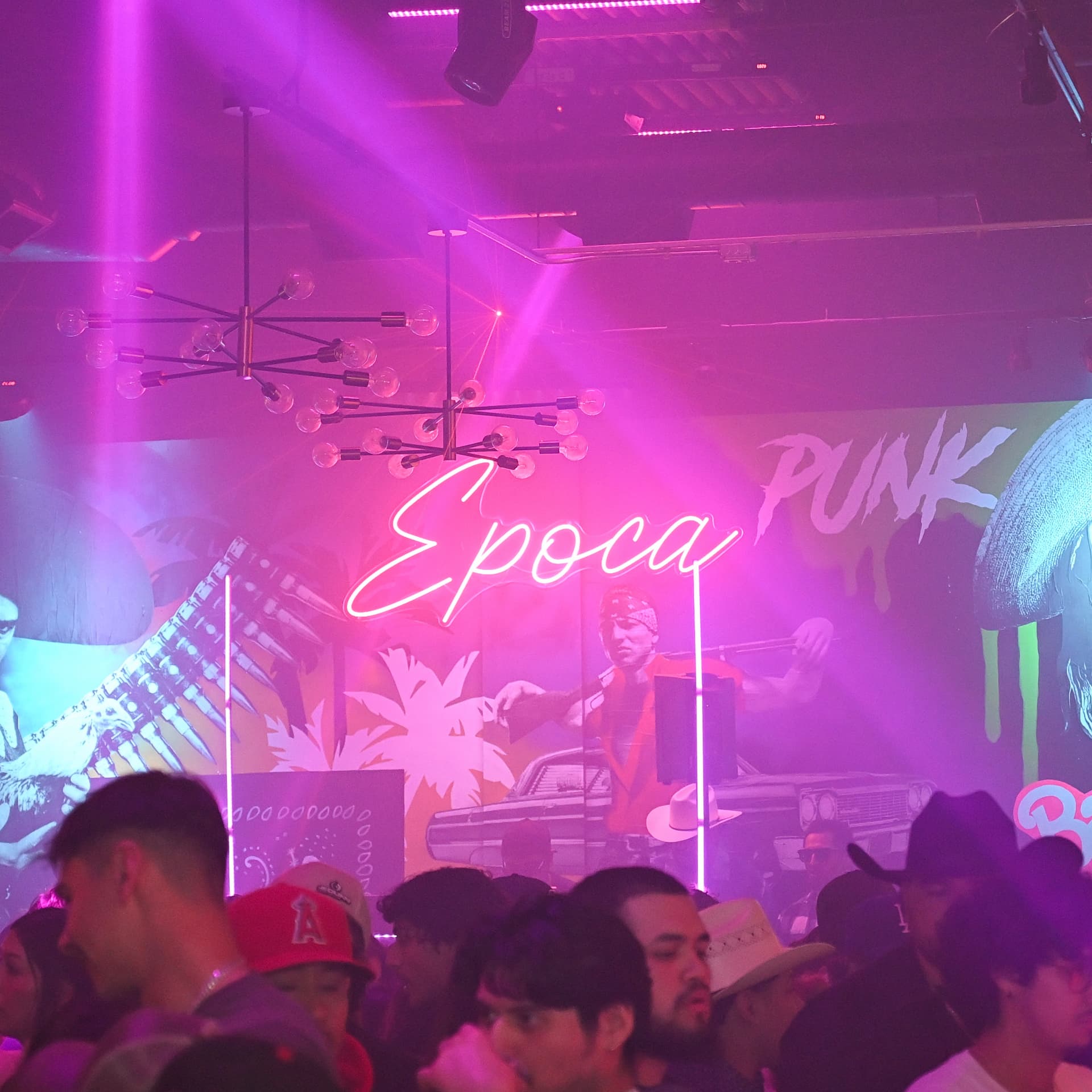 Época neon sign glowing over the club murals